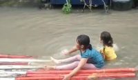 Dua anak di BTN Pemda Lobar sedang bermain saat genangan banjir (istimewa)