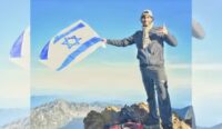 Seorang pendaki mengibarkan bendera Israel di puncak Gunung Rinjani. BTNGR mengklaim itu adalah foto lama.